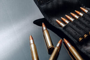 Rifle bullets or cartridges on black shiny background close up